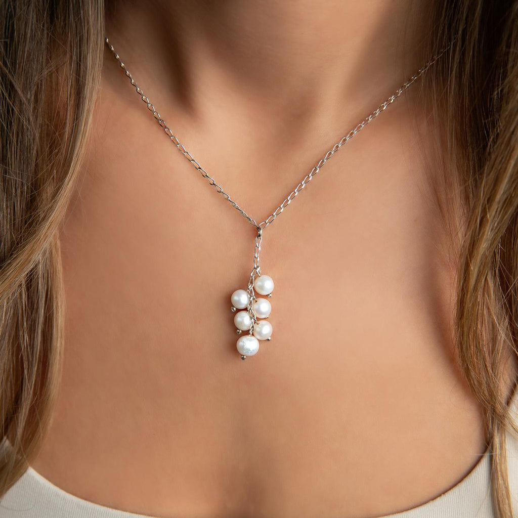 photo of a brunette model wearing a silver pearl drop necklace
