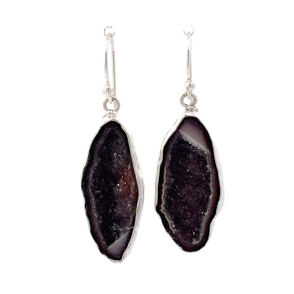 photo of long pair of silver geode earrings on a white background
