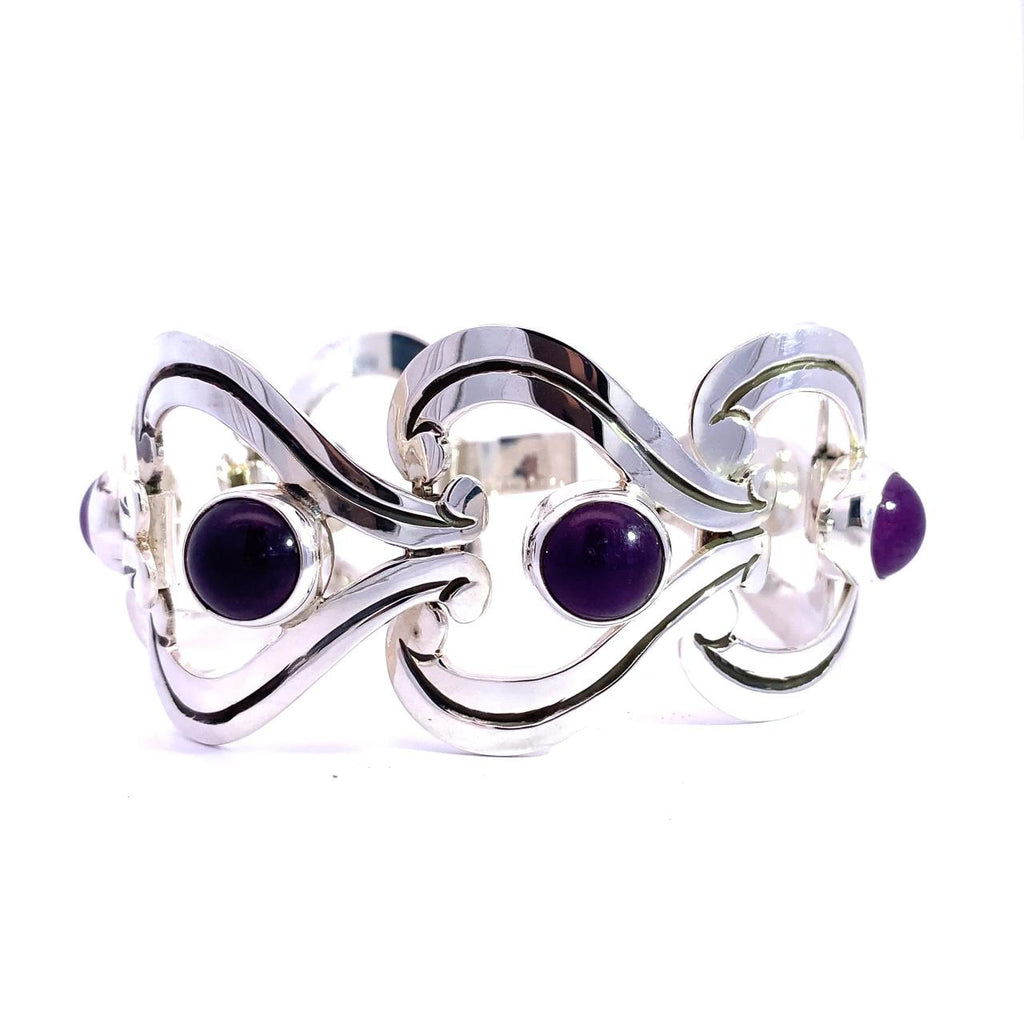 photo of a sterling silver open link bracelet set with Amethysts on a white background
