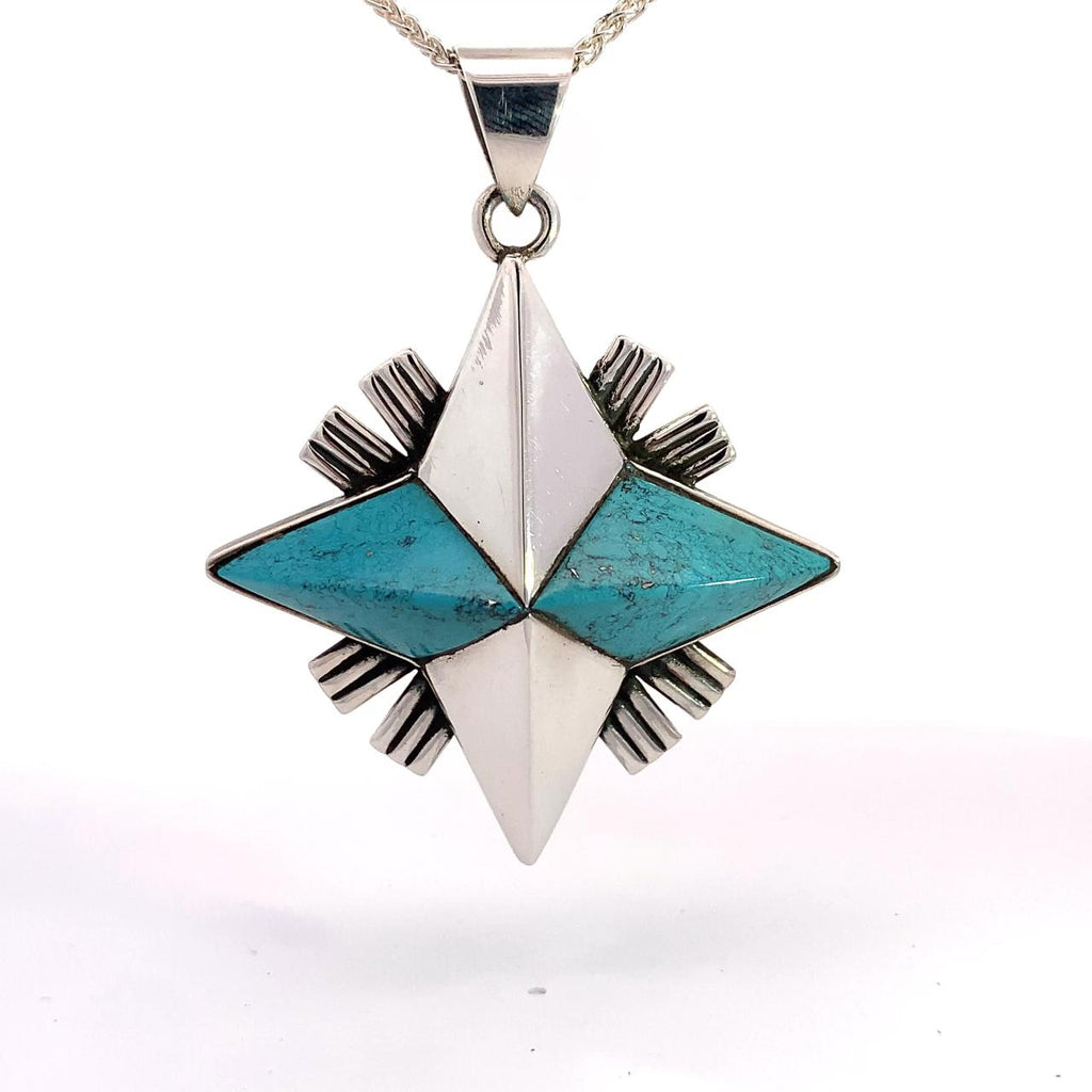 photo of a sterling silver four point star turquoise pendant on a white background