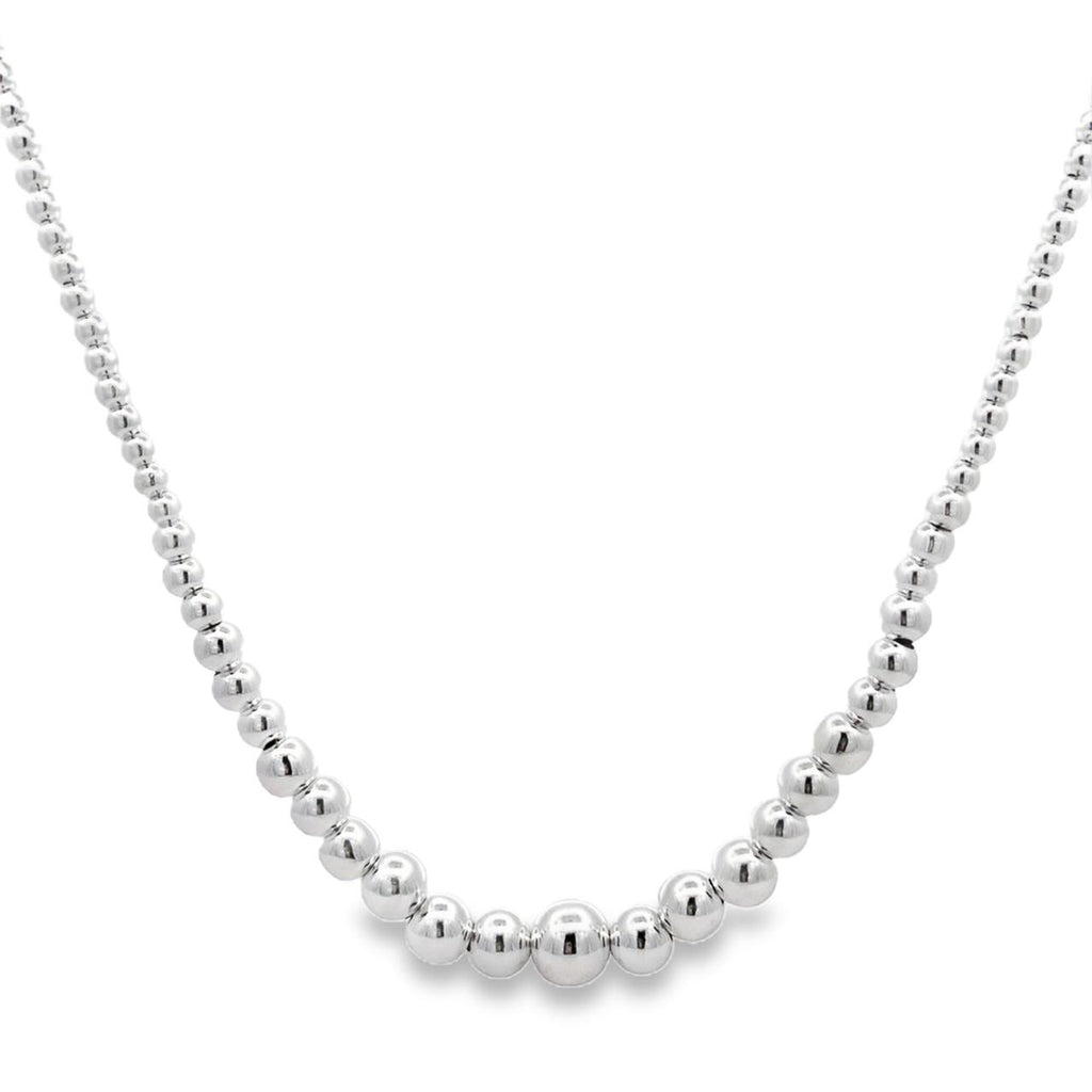 photo of a silver tapering bead necklace on a white background