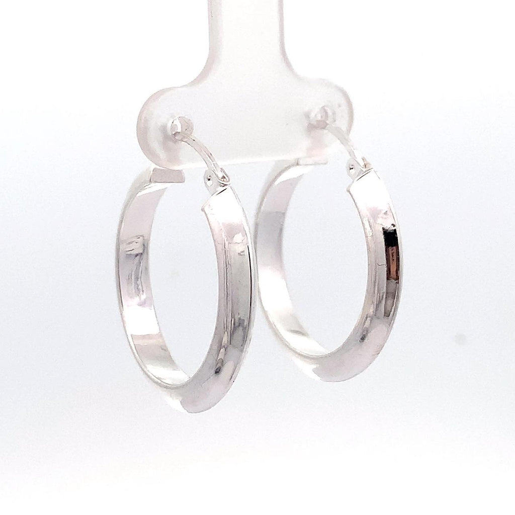 Taxco artisan sterling silver 1 inch hoop earrings worn by model, polished Mexican silver hoops with latch closure